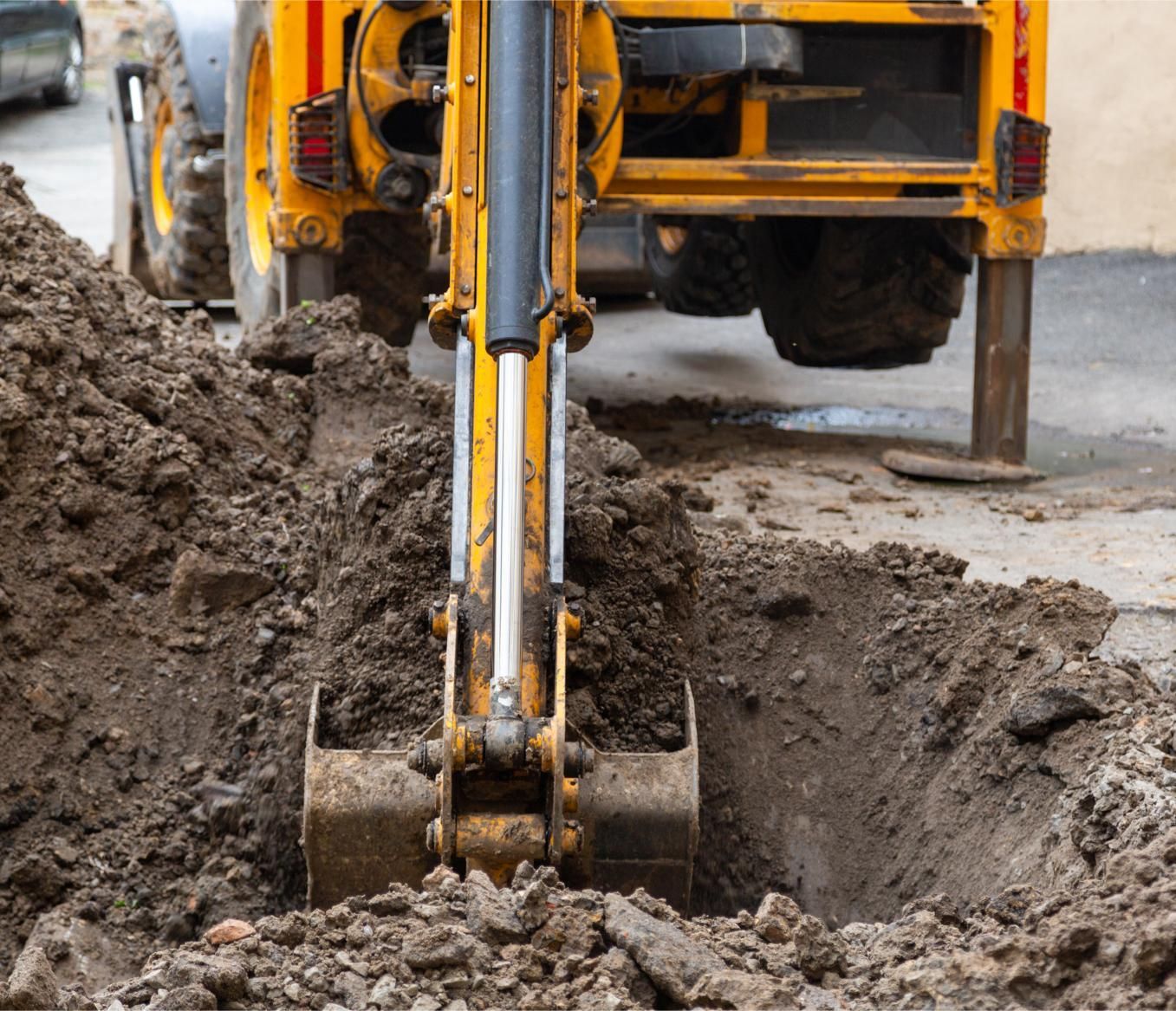 a yellow excavator is digging a hole in the ground