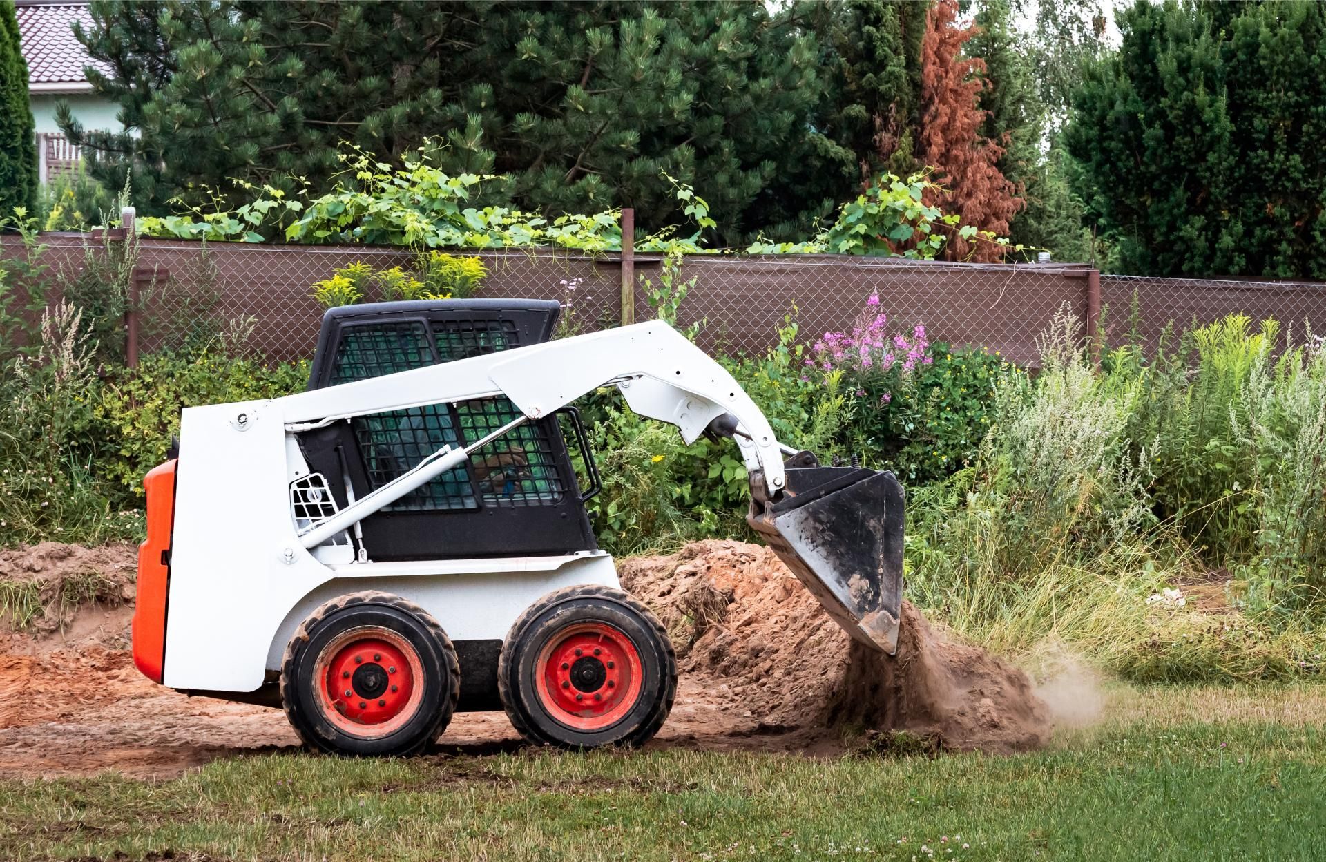 a bulldozer is digging a hole in the grass