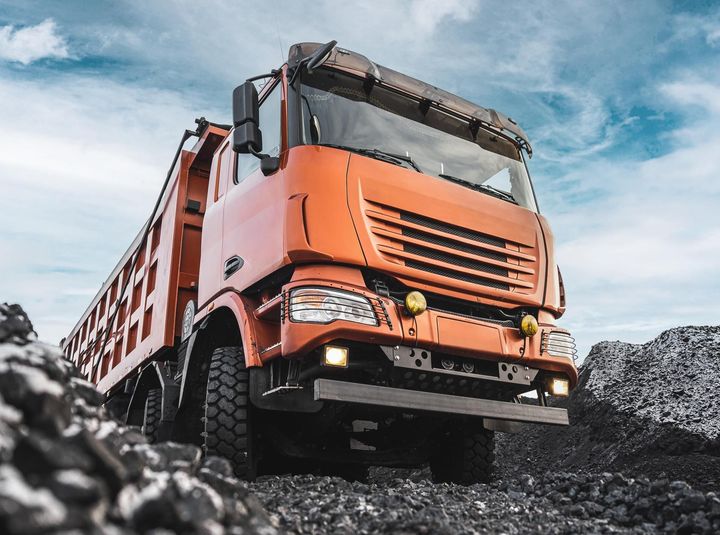 a large orange dump truck with a license plate that says ' sd ' on it