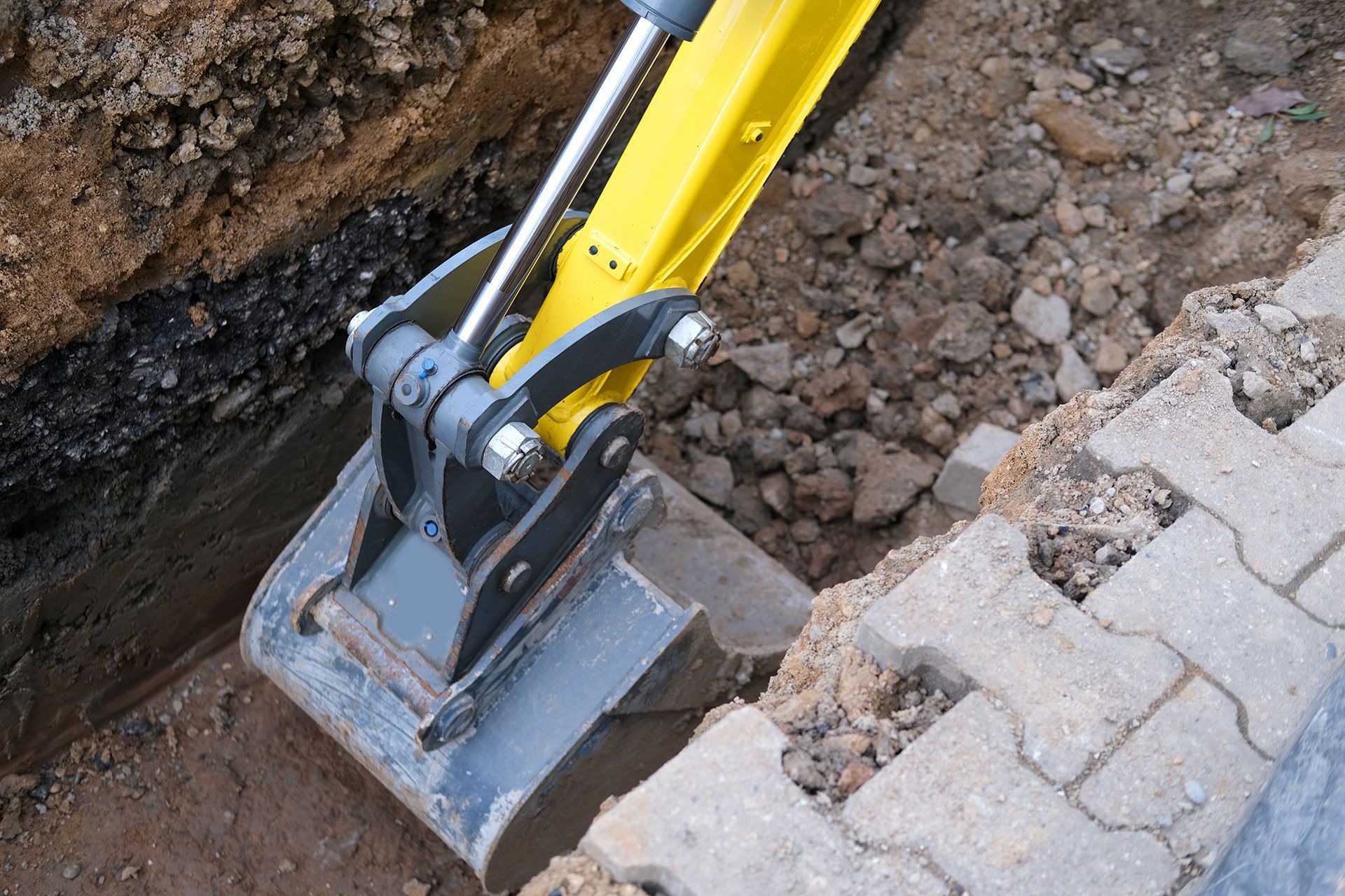 a yellow excavator is digging a hole in the ground