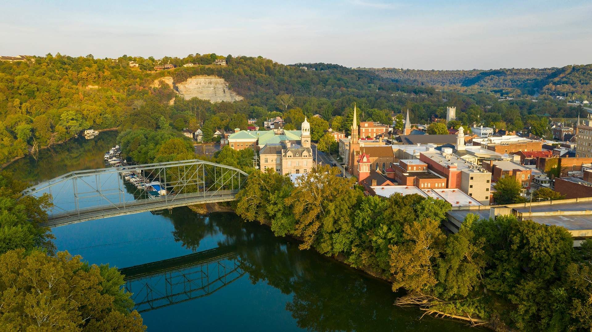 a bridge over a river with a city in the background