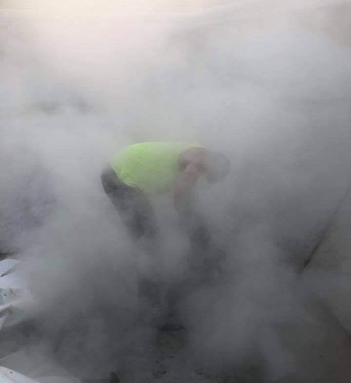 A man is working for site grading but it's very dusty while work is going on.